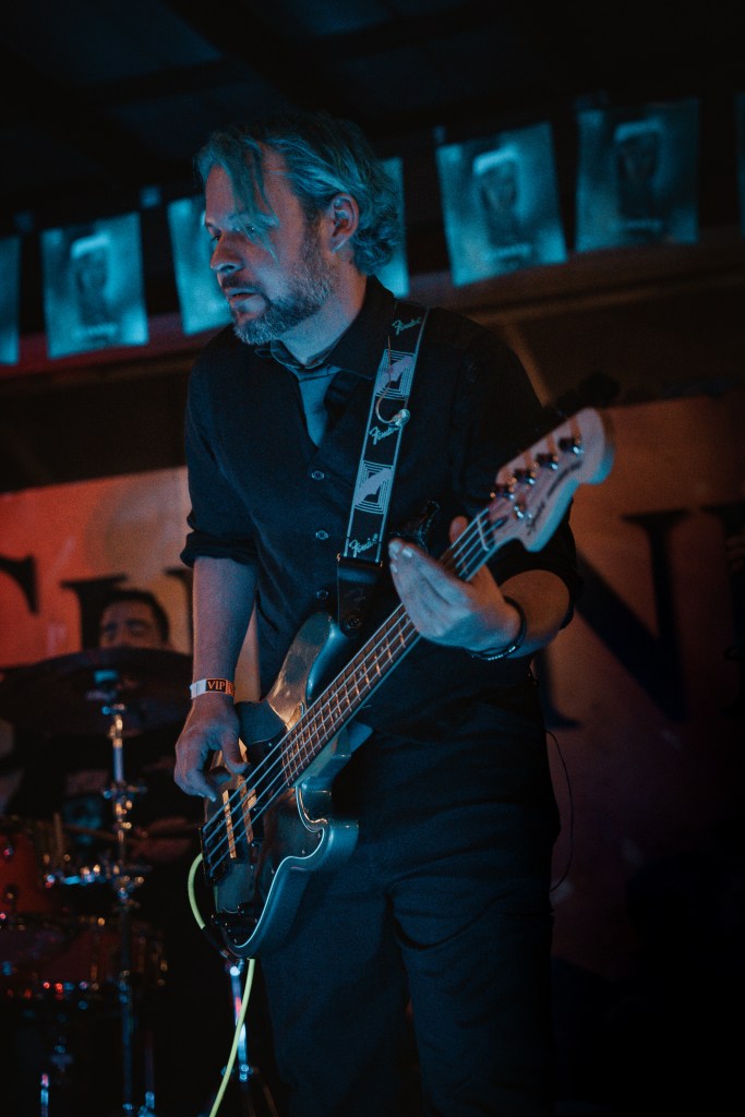 photograph of musician playing guitar on stage